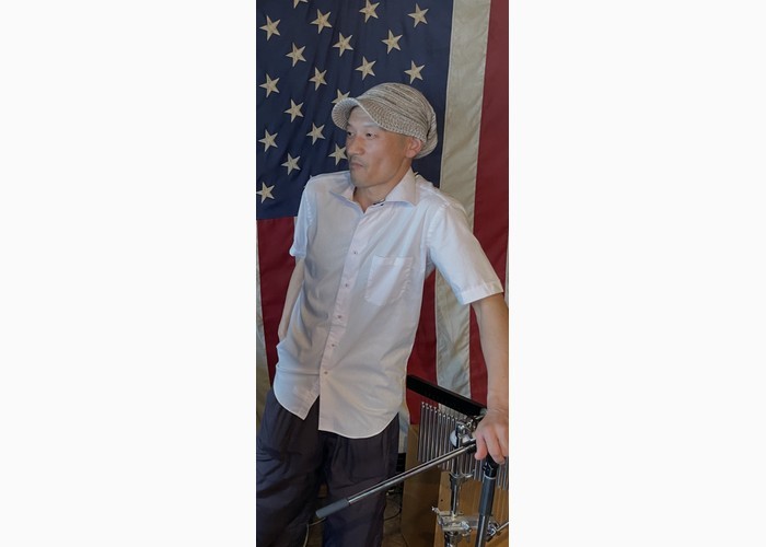 アメリカ国旗の前に立つけいちゃんの写真